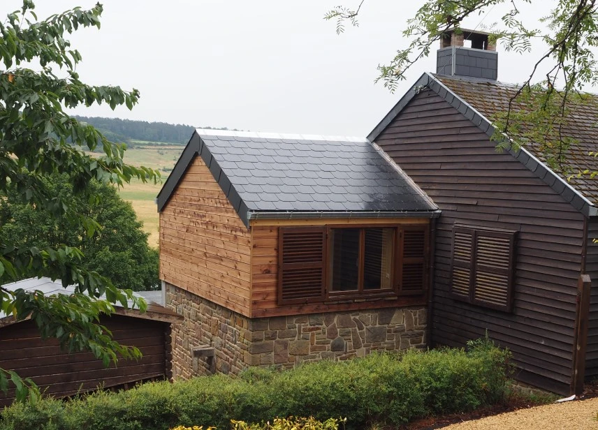 Afgewerkte aanbouw met natuurstenen muur en houten bekleding door NSS-Constructie voor duurzaam vakmanschap